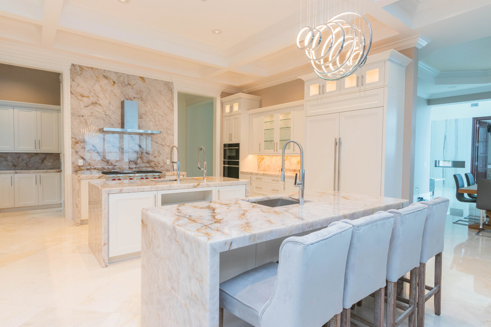 Photo of an expansive transitional u-shaped open plan kitchen in Other with an undermount sink, flat-panel cabinets, white cabinets, quartzite benchtops, white splashback, stone slab splashback, marble floors, multiple islands and white floor.