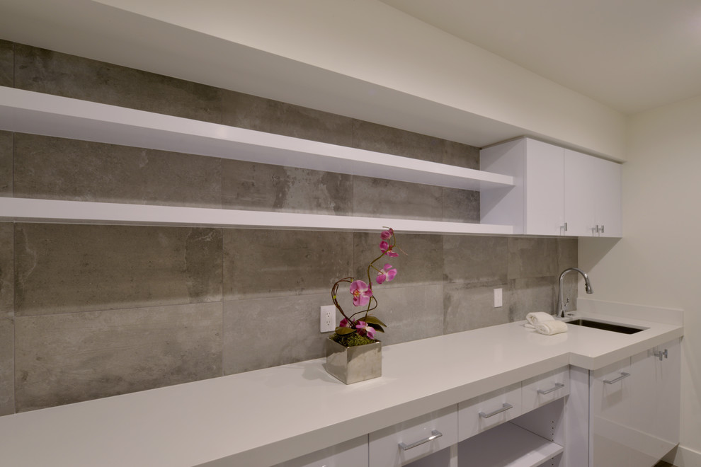 Photo of a large modern single-wall kitchen pantry in San Diego with an undermount sink, flat-panel cabinets, white cabinets, quartz benchtops, white splashback, cement tile splashback, light hardwood floors and no island.