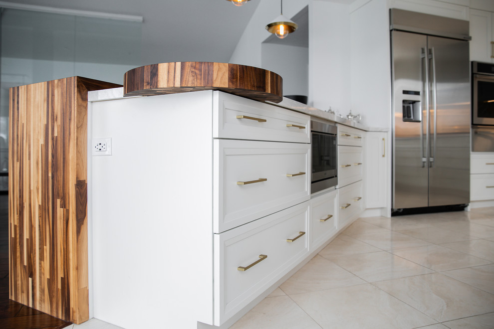 Eat-in kitchen - large transitional u-shaped eat-in kitchen idea in Toronto with an undermount sink, shaker cabinets, white cabinets, quartz countertops, gray backsplash, subway tile backsplash, stainless steel appliances, white countertops and a peninsula