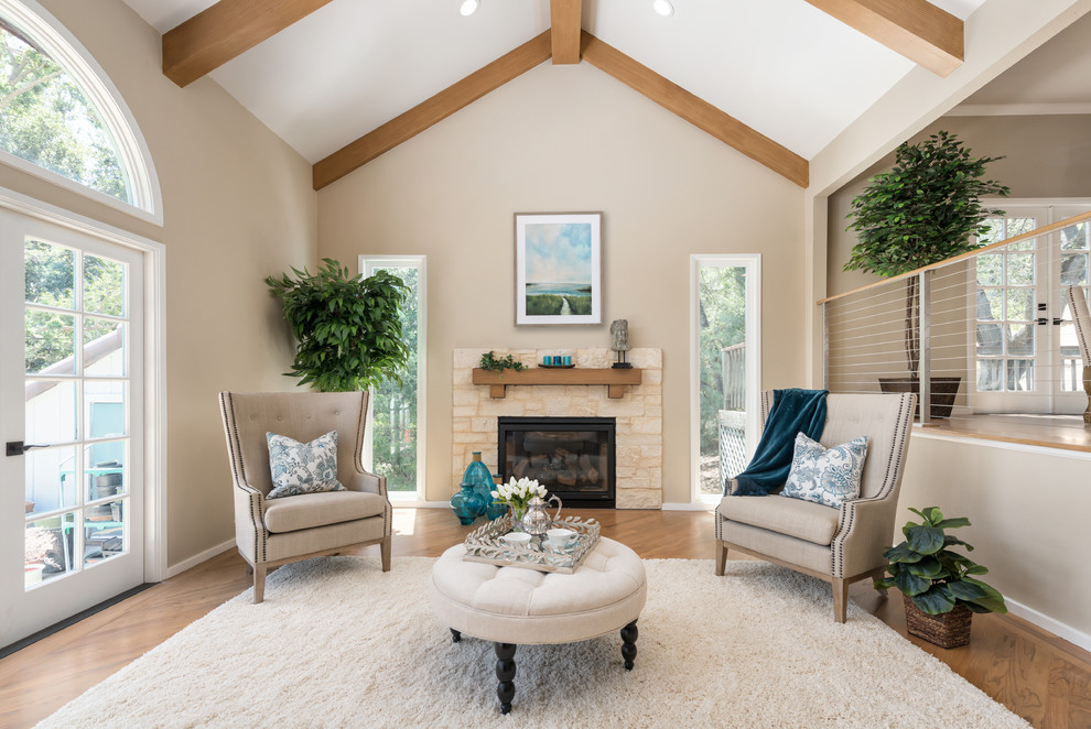 This is an example of a mid-sized transitional formal enclosed living room in San Francisco with beige walls, light hardwood floors, a standard fireplace, a stone fireplace surround and no tv.