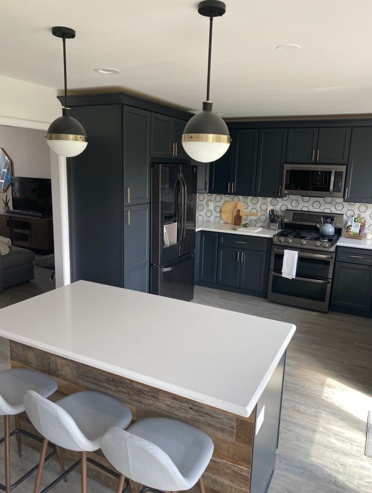 Design ideas for a mid-sized country u-shaped eat-in kitchen in Chicago with an undermount sink, shaker cabinets, grey cabinets, quartz benchtops, grey splashback, porcelain splashback, stainless steel appliances, vinyl floors, with island, brown floor and white benchtop.