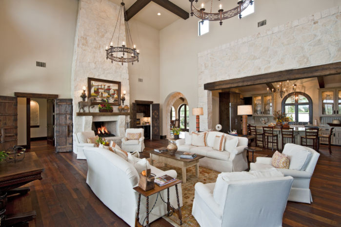 Design ideas for an expansive mediterranean formal open concept living room in Austin with white walls, medium hardwood floors, a standard fireplace and a stone fireplace surround.