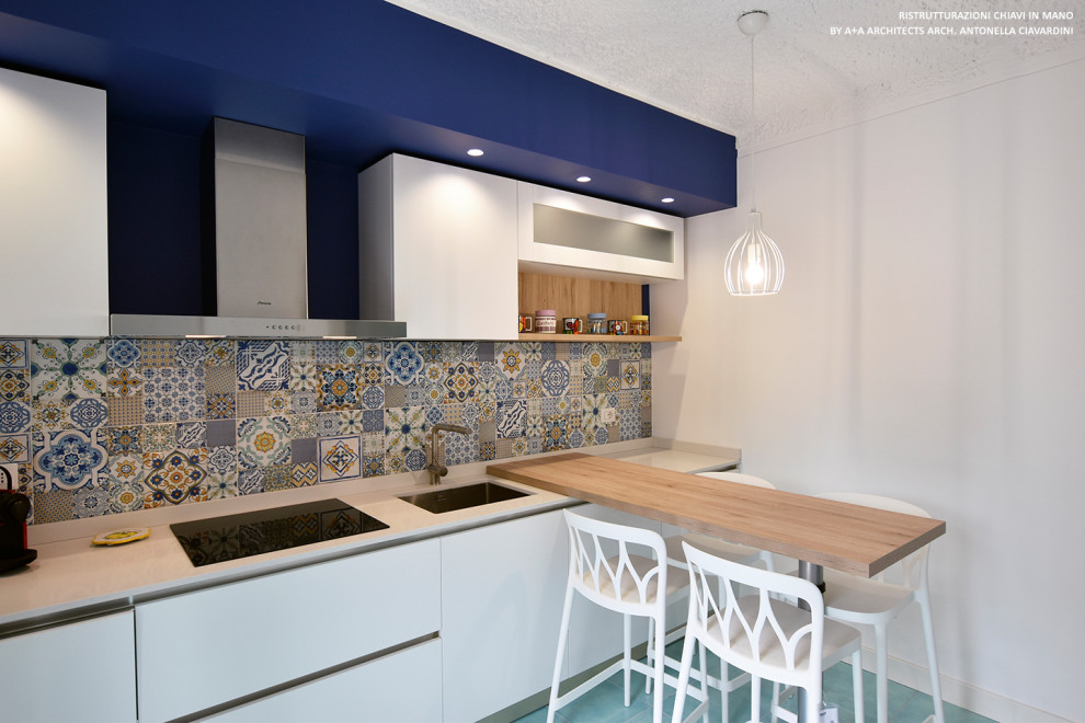 Small mediterranean galley separate kitchen in Other with an undermount sink, flat-panel cabinets, white cabinets, quartz benchtops, multi-coloured splashback, ceramic splashback, stainless steel appliances, porcelain floors, a peninsula, turquoise floor and white benchtop.