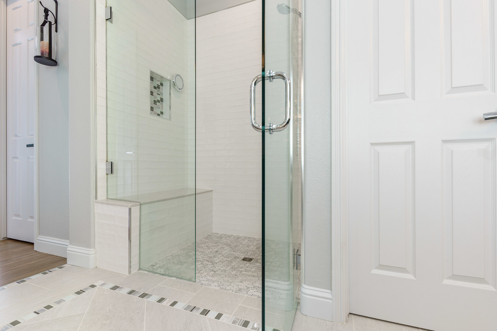 This is an example of a mid-sized traditional master bathroom in Other with shaker cabinets, green cabinets, a corner tub, a corner shower, a one-piece toilet, white tile, subway tile, grey walls, terra-cotta floors, an undermount sink, marble benchtops, grey floor, a hinged shower door and white benchtops.