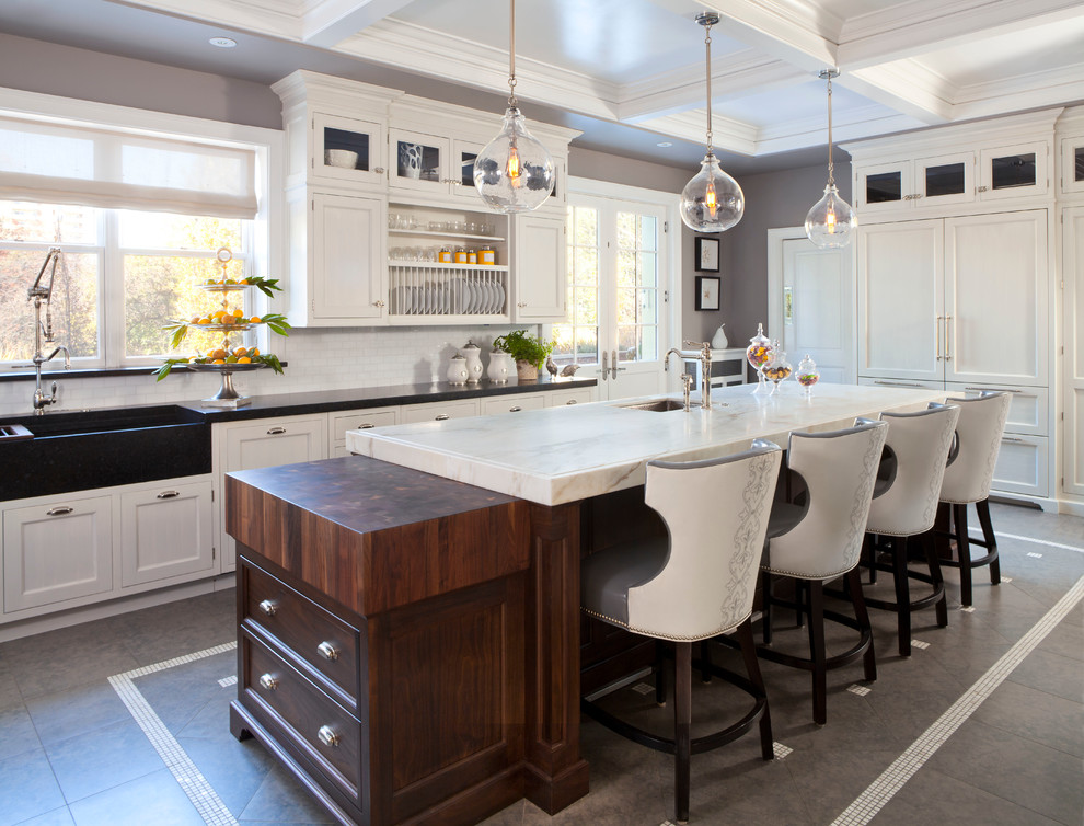 Example of a large transitional l-shaped ceramic tile and gray floor eat-in kitchen design in Denver with a farmhouse sink, shaker cabinets, white cabinets, marble countertops, white backsplash, ceramic backsplash, paneled appliances and an island