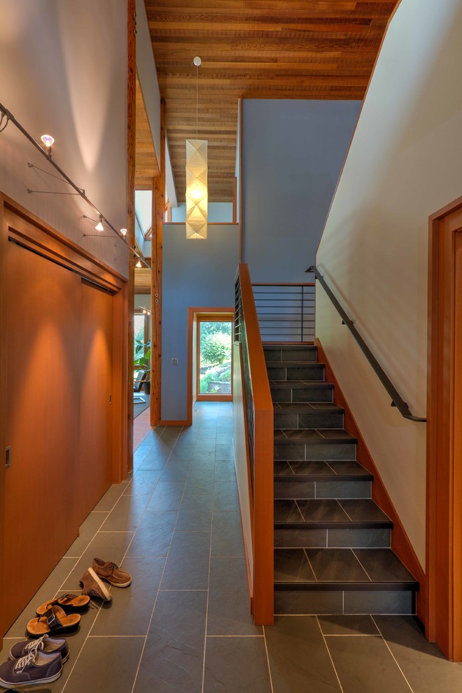 This is an example of a mid-sized contemporary tile straight staircase in Seattle with tile risers and metal railing.