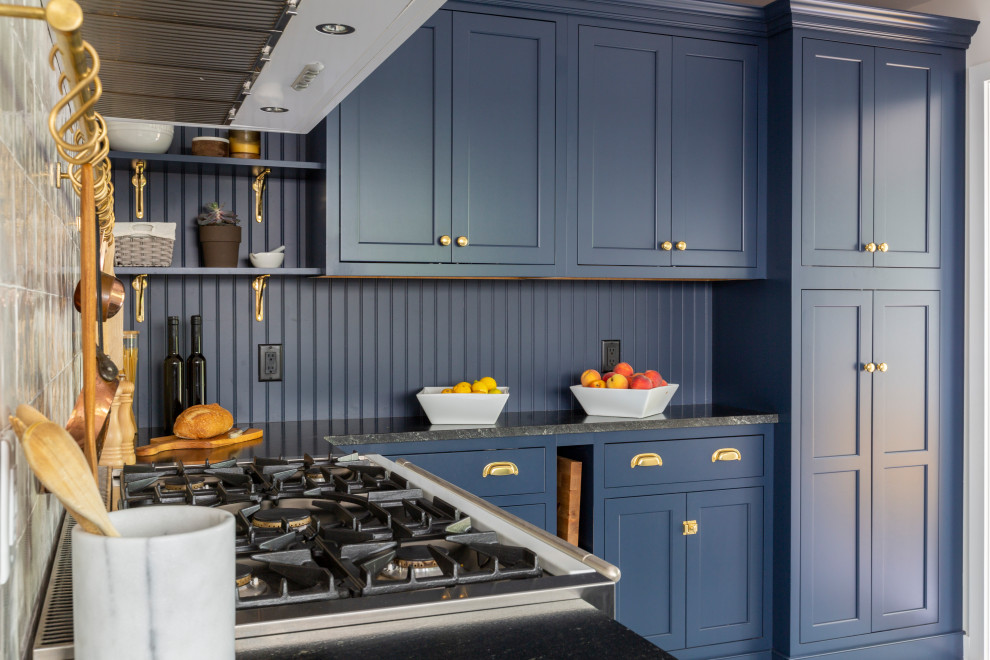 Inredning av ett avskilt, litet svart svart u-kök, med en rustik diskho, skåp i shakerstil, blå skåp, granitbänkskiva, vitt stänkskydd, vita vitvaror, skiffergolv och grått golv