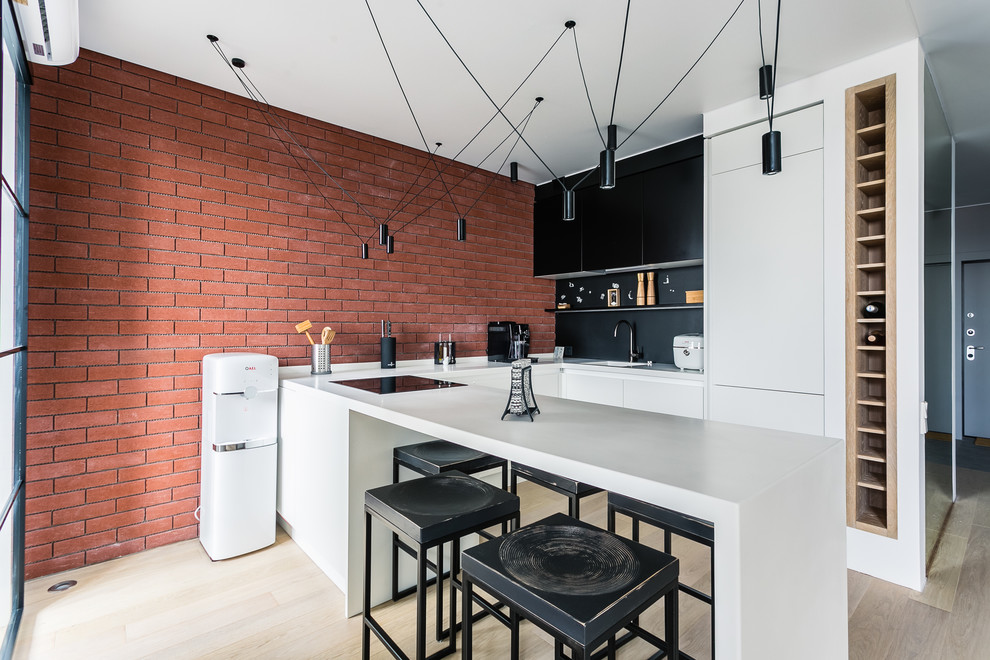 Industrial u-shaped kitchen in Moscow with a single-bowl sink, flat-panel cabinets, black splashback, light hardwood floors, a peninsula, beige floor and white benchtop.