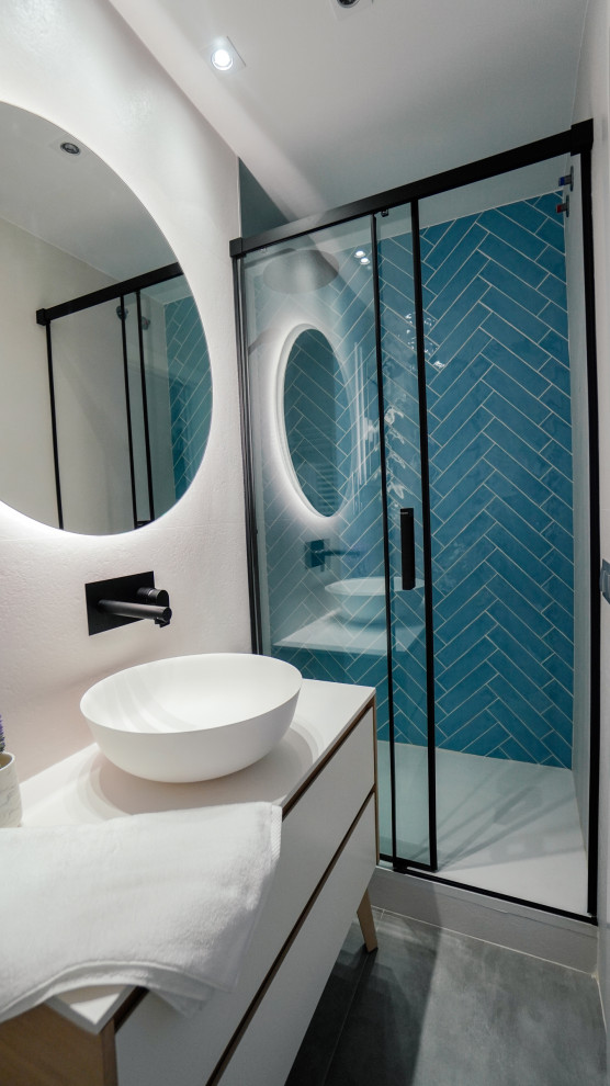 Bathroom - mid-sized contemporary master blue tile and ceramic tile concrete floor, gray floor and single-sink bathroom idea in Barcelona with flat-panel cabinets, white cabinets, a one-piece toilet, white walls, a vessel sink, laminate countertops, white countertops and a freestanding vanity