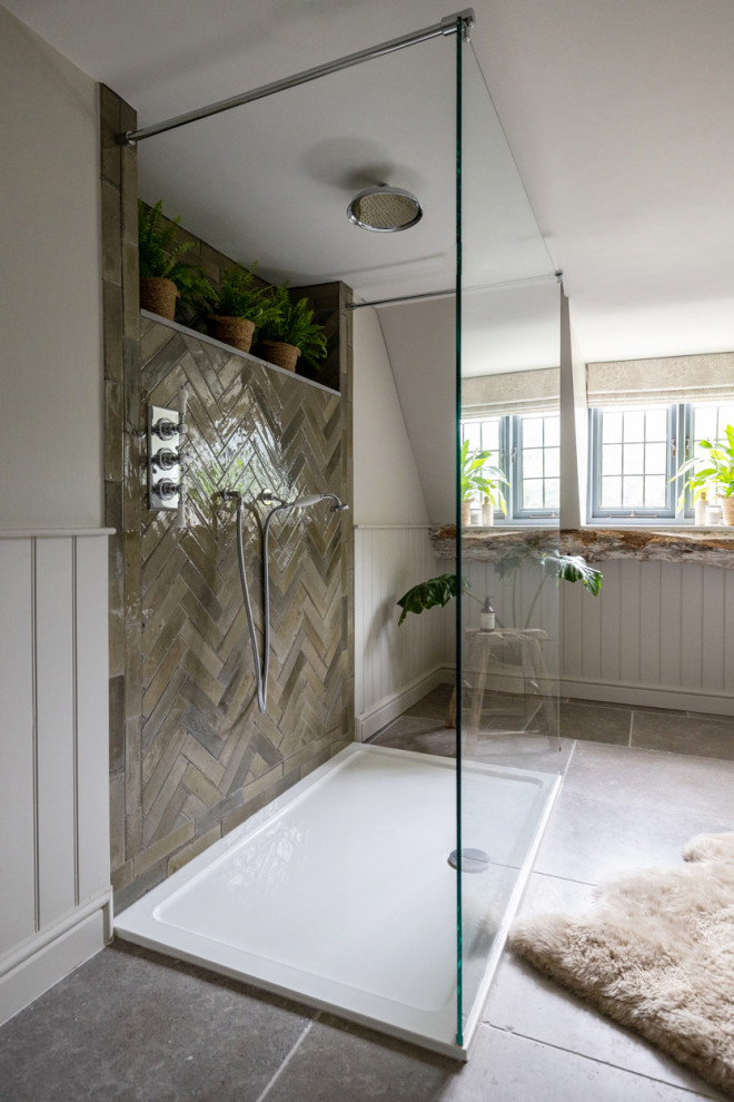 This is an example of a mid-sized country kids bathroom in Gloucestershire with an open shower, a two-piece toilet, green tile, porcelain tile, grey walls, limestone floors, a pedestal sink, grey floor, a single vanity and planked wall panelling.