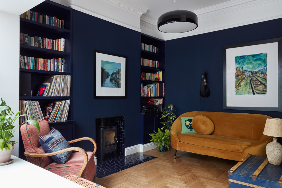 Свежая идея для дизайна: гостиная комната среднего размера в стиле фьюжн с синими стенами, светлым паркетным полом, печью-буржуйкой, фасадом камина из плитки и бежевым полом - отличное фото интерьера