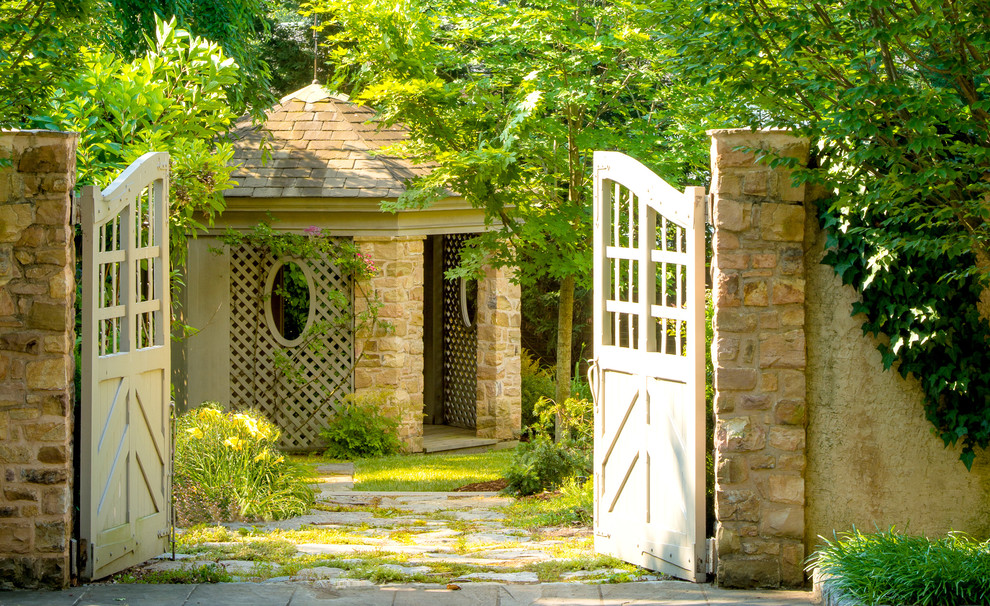 Inspiration for a mid-sized french country backyard stone and stone fence landscaping in DC Metro for summer.