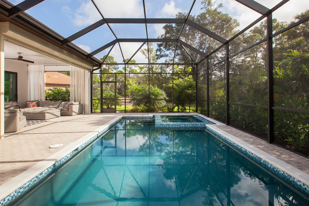 This is an example of a transitional backyard rectangular lap pool in Other with a hot tub and brick pavers.