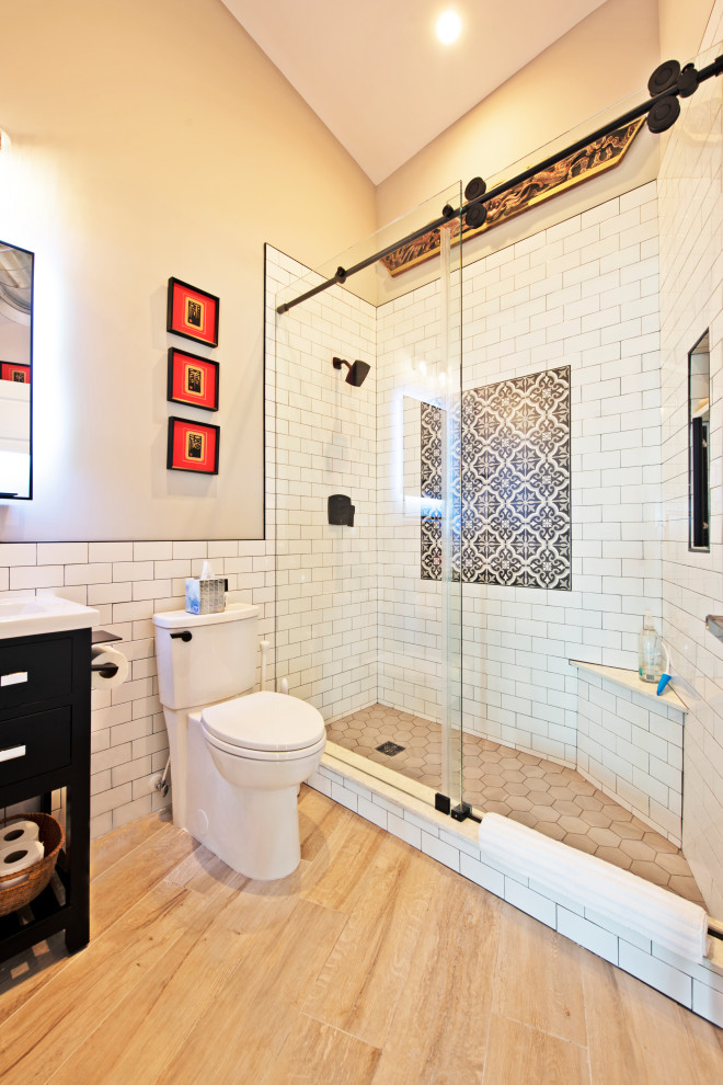 Exempel på ett mellanstort maritimt vit vitt badrum med dusch, med släta luckor, svarta skåp, en dusch i en alkov, en toalettstol med hel cisternkåpa, vit kakel, mosaik, beige väggar, ljust trägolv, ett undermonterad handfat, bänkskiva i kvarts, brunt golv och dusch med gångjärnsdörr