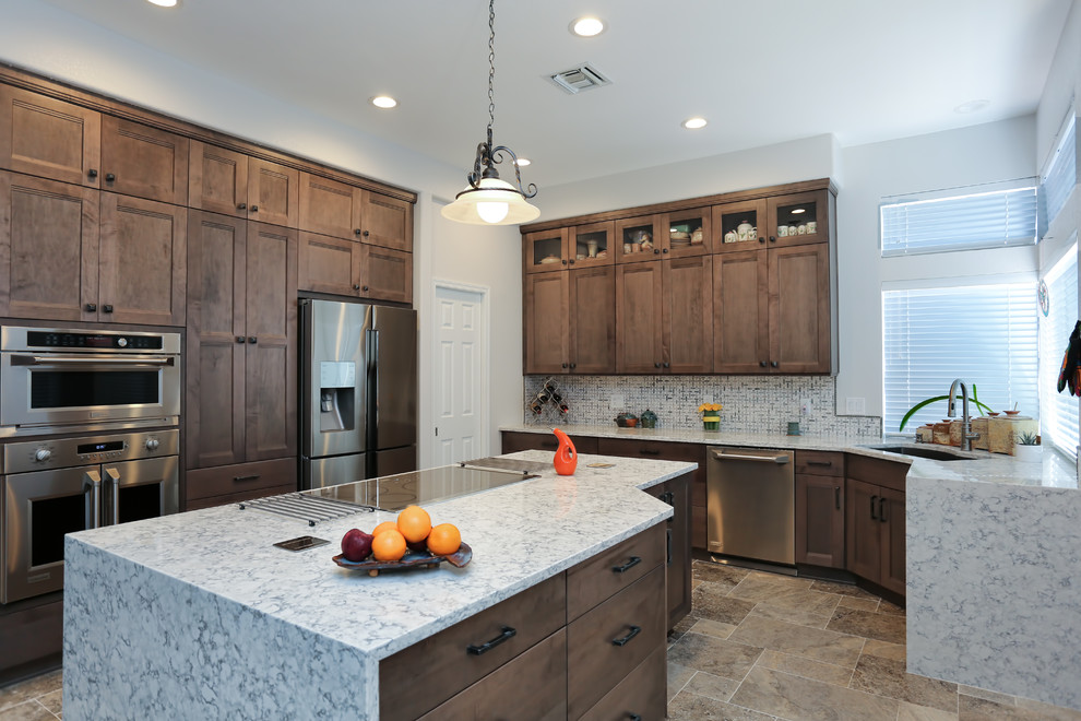 Example of a porcelain tile kitchen design in Phoenix with an undermount sink, shaker cabinets, gray cabinets, quartz countertops, white backsplash, ceramic backsplash, stainless steel appliances and an island