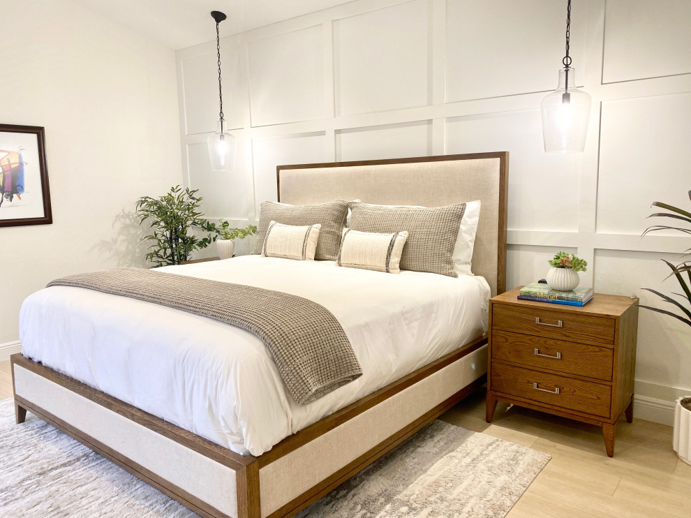 Large beach style master laminate floor, beige floor and wood wall bedroom photo in Miami with white walls