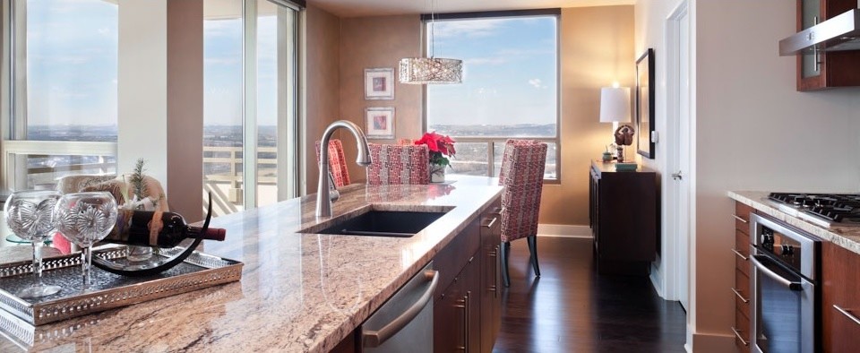 Small transitional galley dark wood floor eat-in kitchen photo in Austin with an undermount sink, flat-panel cabinets, granite countertops, gray backsplash, glass tile backsplash, stainless steel appliances, an island and medium tone wood cabinets