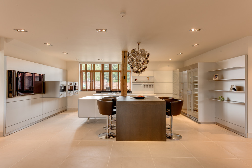 This is an example of an expansive contemporary u-shaped open plan kitchen in Other with flat-panel cabinets, white splashback and multiple islands.
