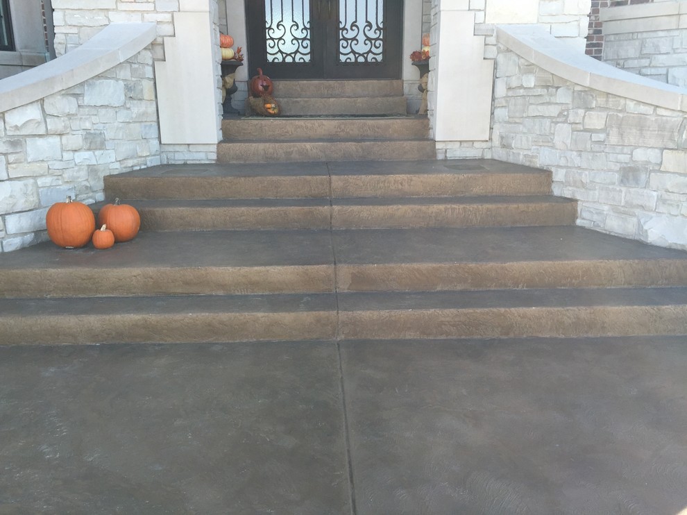 Photo of a mid-sized mediterranean front yard verandah in St Louis with stamped concrete.