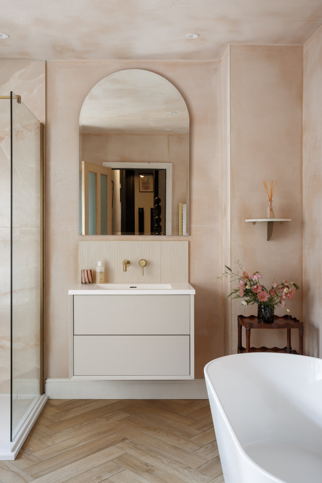 Foto på ett stort vintage badrum för barn, med släta luckor, beige skåp, ett fristående badkar, en öppen dusch, rosa kakel, rosa väggar, mellanmörkt trägolv och ett integrerad handfat