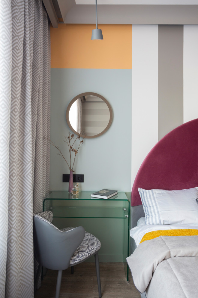 Идея дизайна: хозяйская спальня среднего размера в современном стиле с серыми стенами, полом из ламината, коричневым полом и акцентной стеной