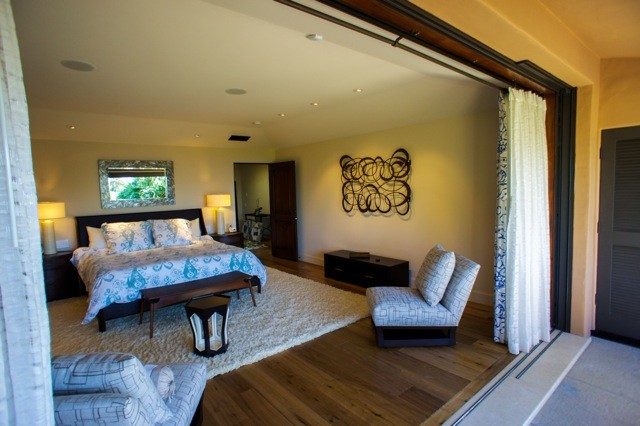 Photo of a medium sized traditional master bedroom in Santa Barbara with beige walls, medium hardwood flooring, a corner fireplace and a concrete fireplace surround.