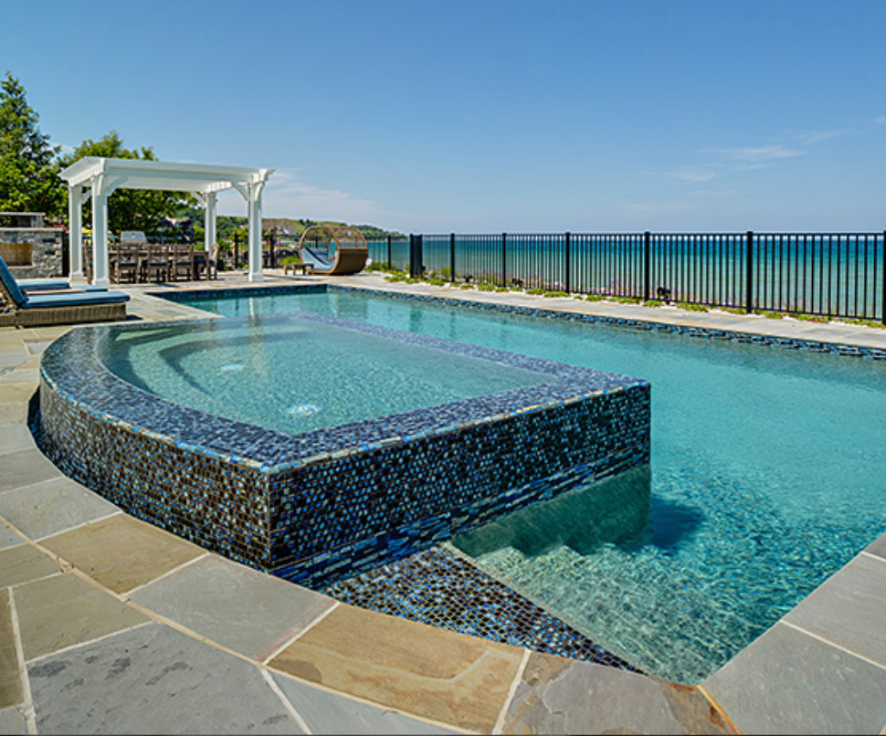 Example of a large transitional backyard stone and custom-shaped natural hot tub design