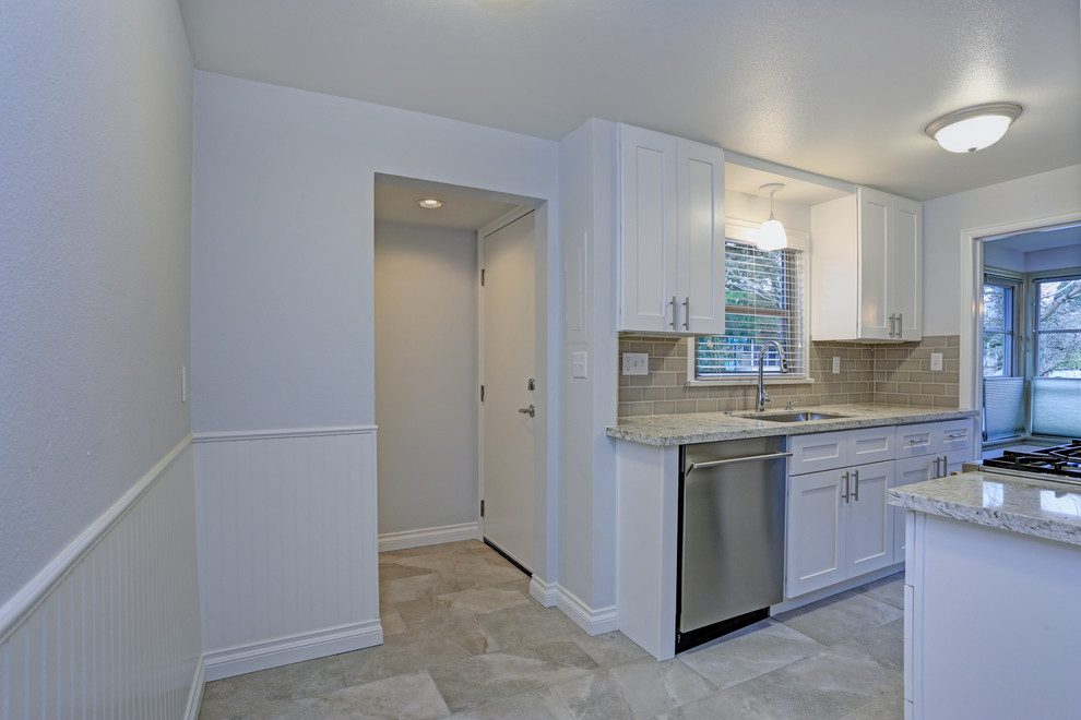Kitchen - transitional kitchen idea with shaker cabinets, white cabinets, granite countertops, beige backsplash, cement tile backsplash, no island and multicolored countertops