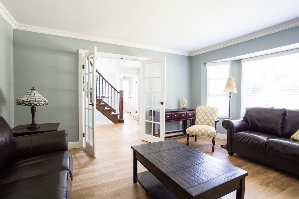 Inspiration for a mid-sized transitional enclosed medium tone wood floor living room remodel in Vancouver with green walls, a standard fireplace and a stone fireplace