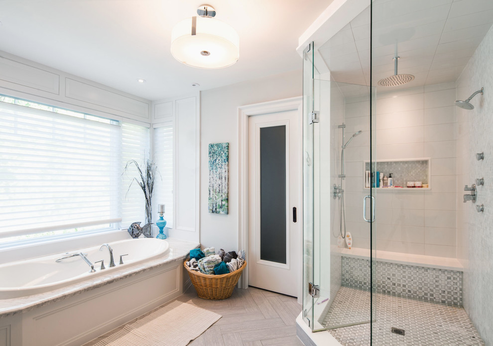 Design ideas for a mid-sized transitional master bathroom in Toronto with shaker cabinets, white cabinets, a drop-in tub, a corner shower, a one-piece toilet, gray tile, mosaic tile, grey walls, ceramic floors, a drop-in sink, marble benchtops, beige floor and a hinged shower door.