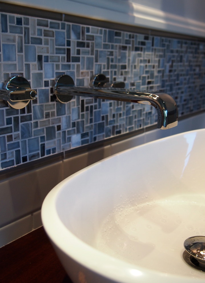 Inspiration for a large transitional master blue tile and mosaic tile porcelain tile freestanding bathtub remodel with a vessel sink, furniture-like cabinets, dark wood cabinets, wood countertops, a one-piece toilet and blue walls
