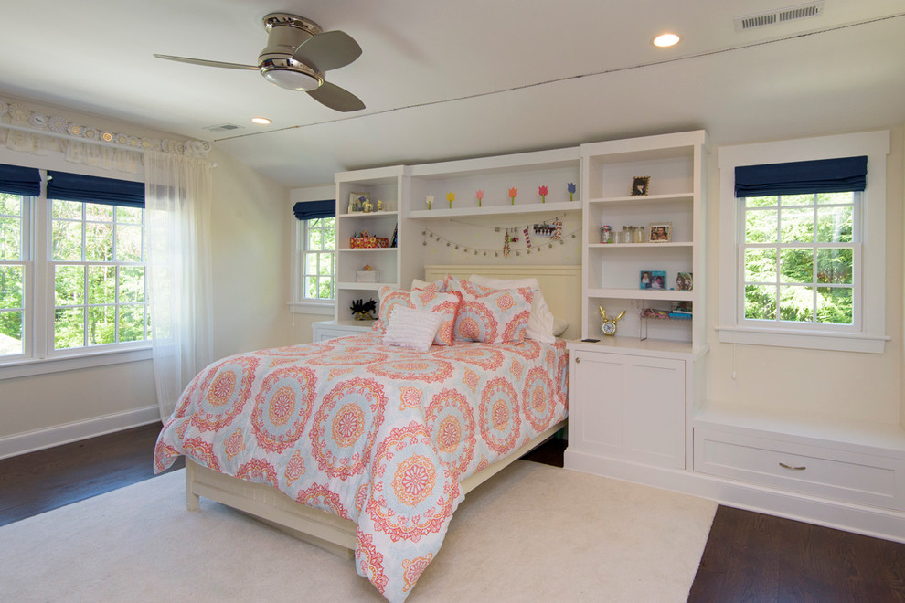 This is an example of a mid-sized country kids' room for girls in New York with blue walls and dark hardwood floors.