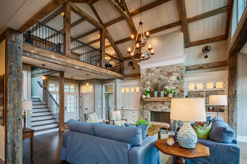 Mid-sized country open concept living room in Other with beige walls, dark hardwood floors, a standard fireplace, a stone fireplace surround and brown floor.