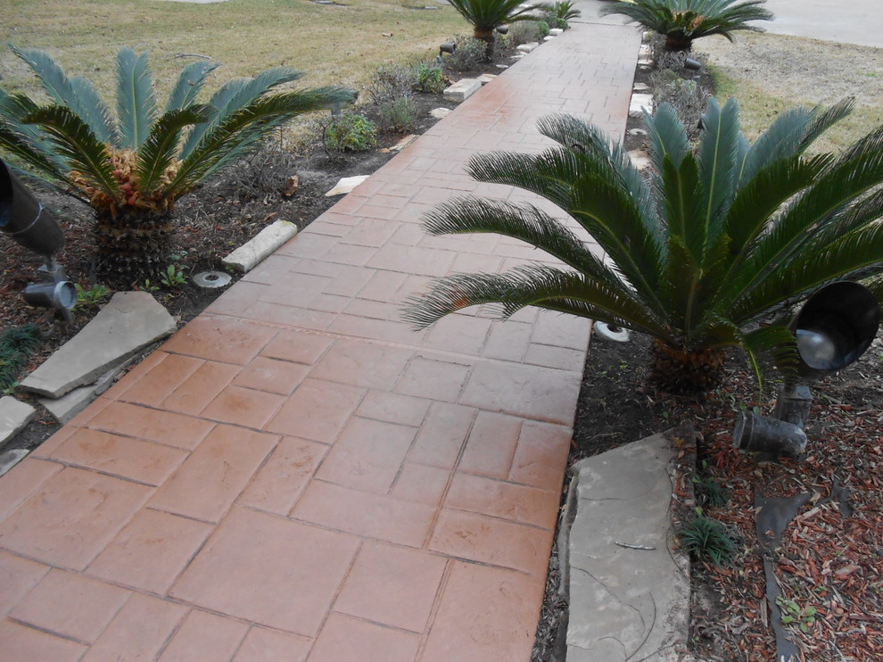 Design ideas for a mid-sized tropical front yard garden in Houston with a garden path and concrete pavers.