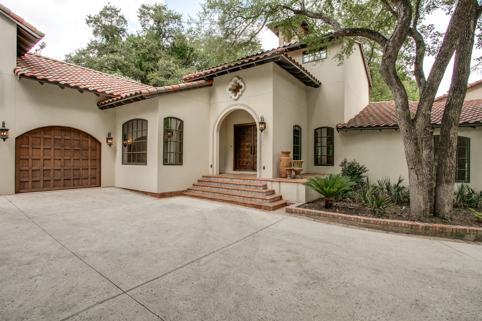 This is an example of a large mediterranean two-storey stucco beige exterior in Dallas.