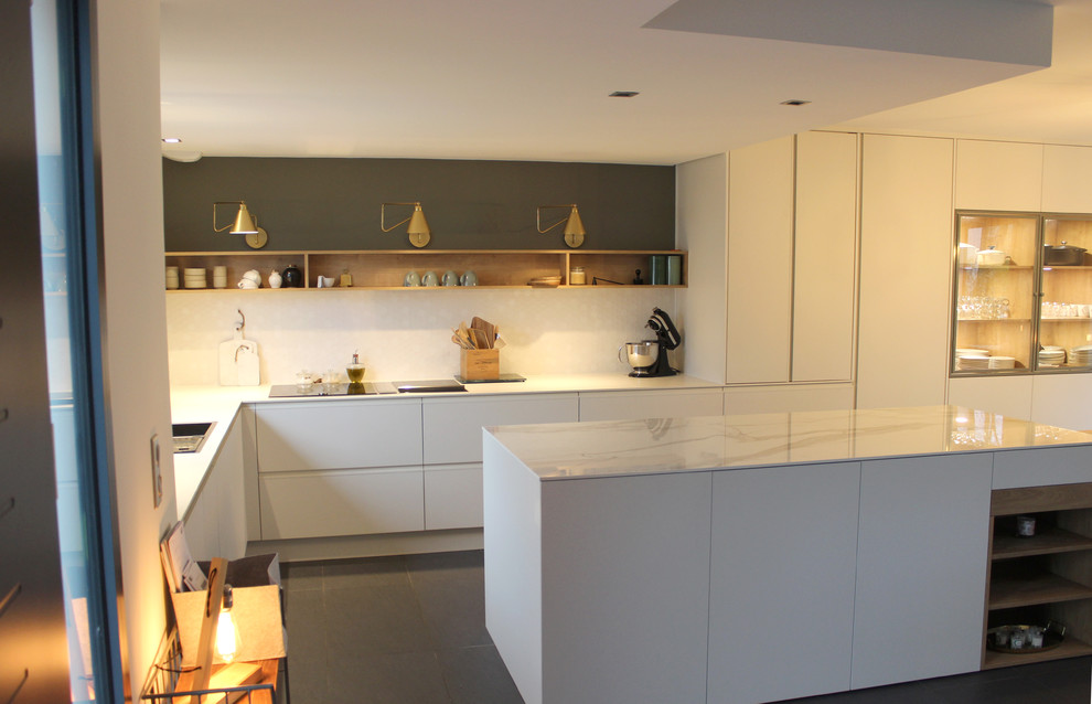 Inspiration for a large scandinavian l-shaped open plan kitchen in Angers with a double-bowl sink, glass-front cabinets, white cabinets, quartz benchtops, white splashback, mosaic tile splashback, stainless steel appliances, with island and grey floor.