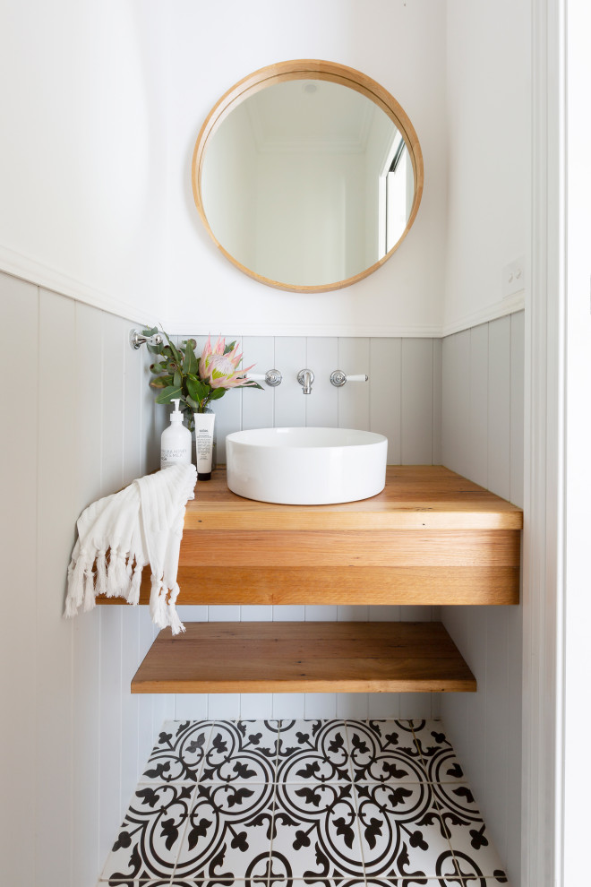 Small traditional powder room in Canberra - Queanbeyan with light wood cabinets, a one-piece toilet, grey walls, porcelain floors, a vessel sink, wood benchtops, blue floor, a built-in vanity and decorative wall panelling.