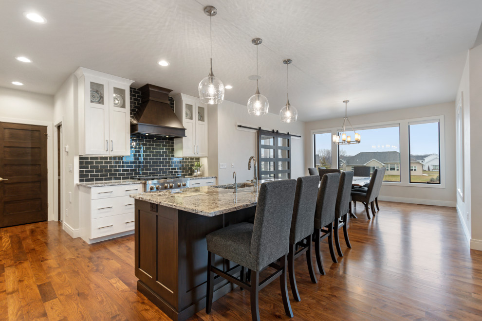 Eat-in kitchen - mid-sized transitional l-shaped medium tone wood floor and brown floor eat-in kitchen idea with an undermount sink, shaker cabinets, white cabinets, granite countertops, blue backsplash, subway tile backsplash, stainless steel appliances, an island and multicolored countertops