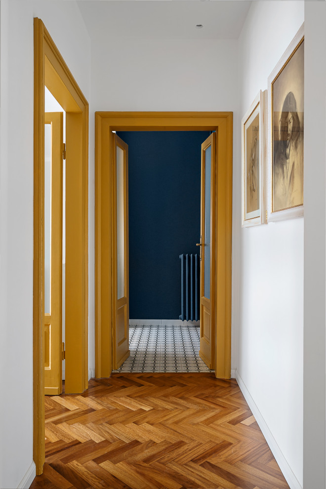 Esempio di un ingresso o corridoio chic di medie dimensioni con pareti bianche e parquet chiaro