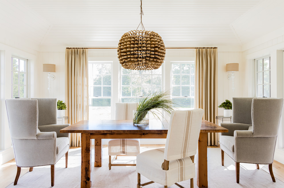 This is an example of a mid-sized transitional separate dining room in Boston with white walls, light hardwood floors, no fireplace and beige floor.