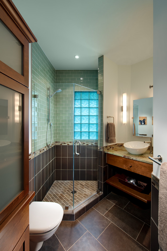 This is an example of an arts and crafts bathroom in DC Metro with a vessel sink, flat-panel cabinets, dark wood cabinets, a corner shower, brown tile, subway tile, a wall-mount toilet, ceramic floors and brown floor.
