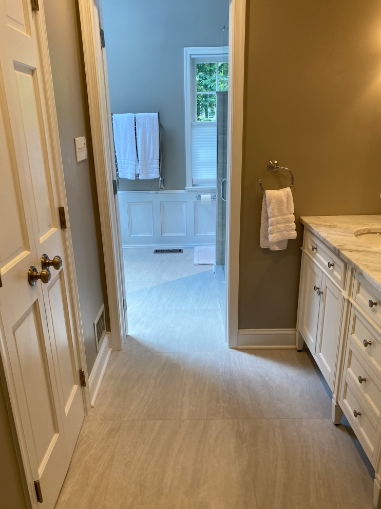 Inspiration for a large modern master white floor, double-sink and wainscoting bathroom remodel in Philadelphia with shaker cabinets, white cabinets, a one-piece toilet, gray walls, a console sink, marble countertops, a hinged shower door, multicolored countertops and a freestanding vanity