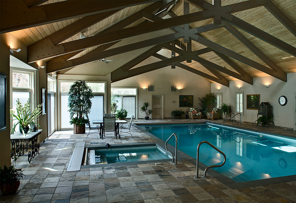 Inspiration for a large traditional indoor rectangular lap pool in Chicago with a pool house and natural stone pavers.