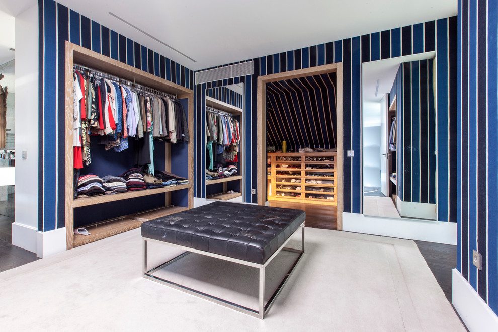 Inspiration for a large contemporary gender-neutral dressing room in Madrid with dark hardwood floors, open cabinets, light wood cabinets and brown floor.