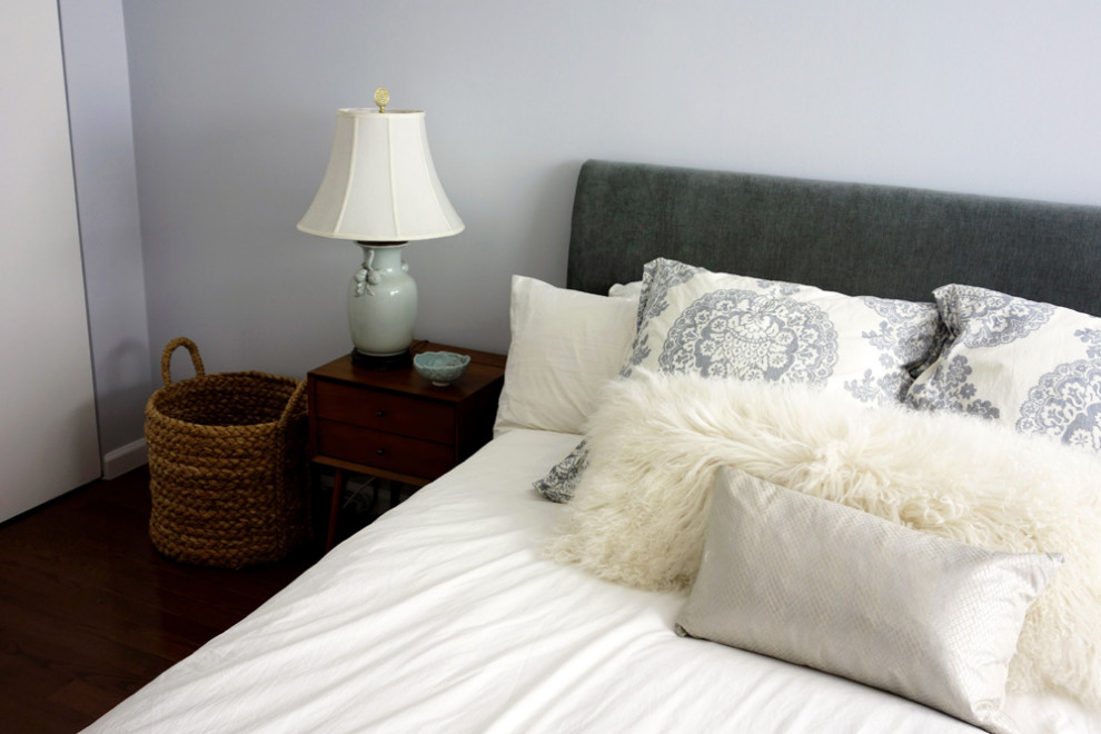 Ispirazione per una camera matrimoniale minimalista di medie dimensioni con pareti bianche, pavimento in legno massello medio e pavimento marrone