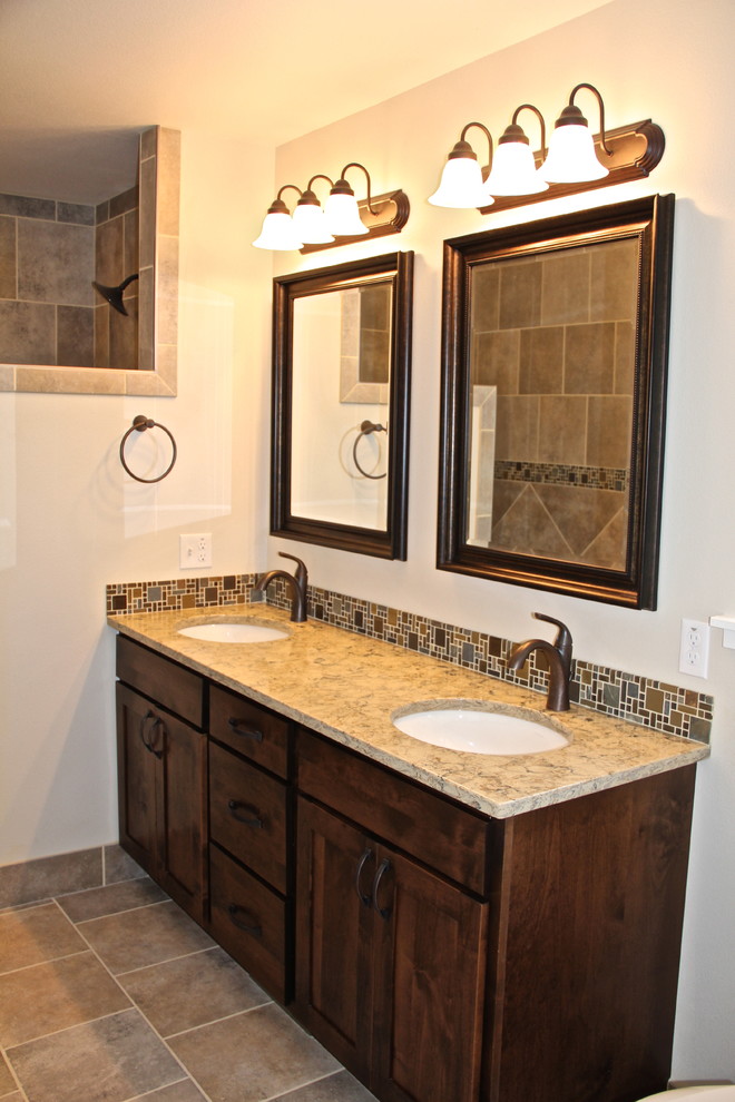 Mountain style master and l-shaped slate floor and brown floor home design photo with dark wood cabinets, an undermount sink, glass-front cabinets, quartz countertops, beige backsplash, ceramic backsplash, colored appliances, an island and brown countertops