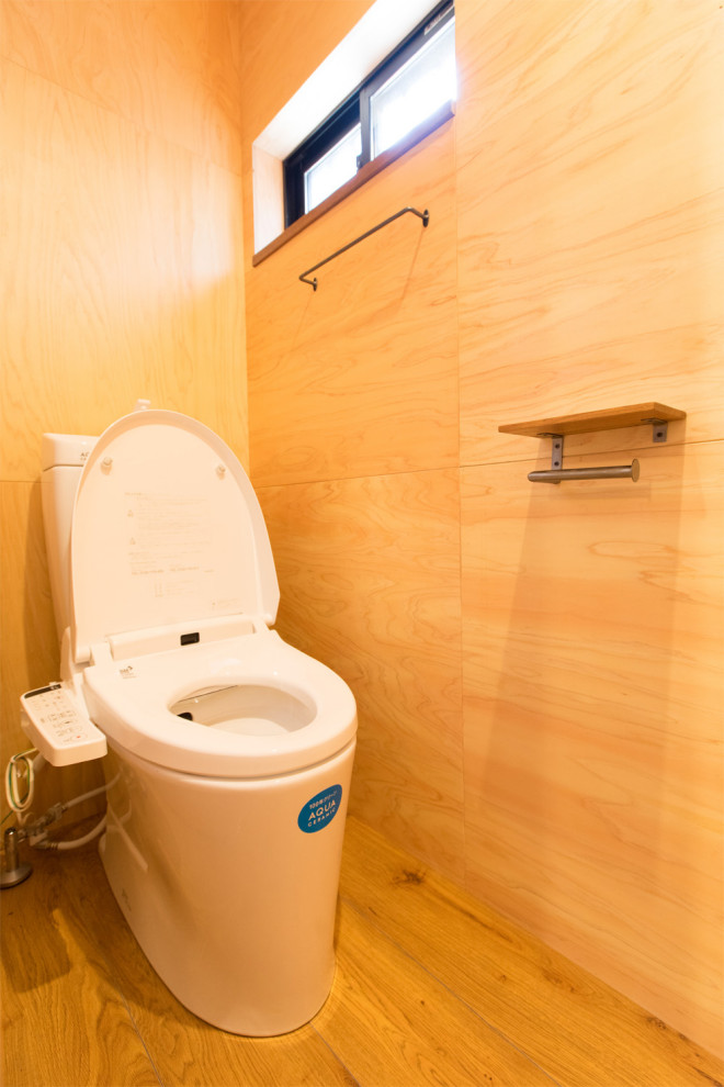 Kleine Gästetoilette mit braunem Boden und Holzwänden in Kobe