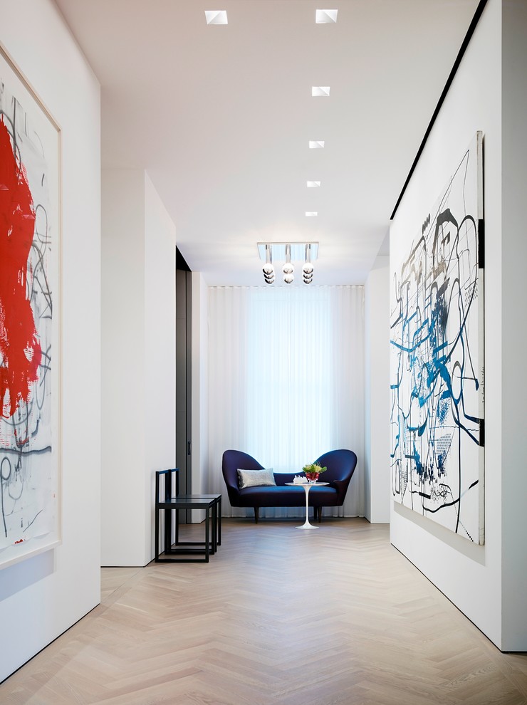 Contemporary hallway in New York with white walls and light hardwood floors.