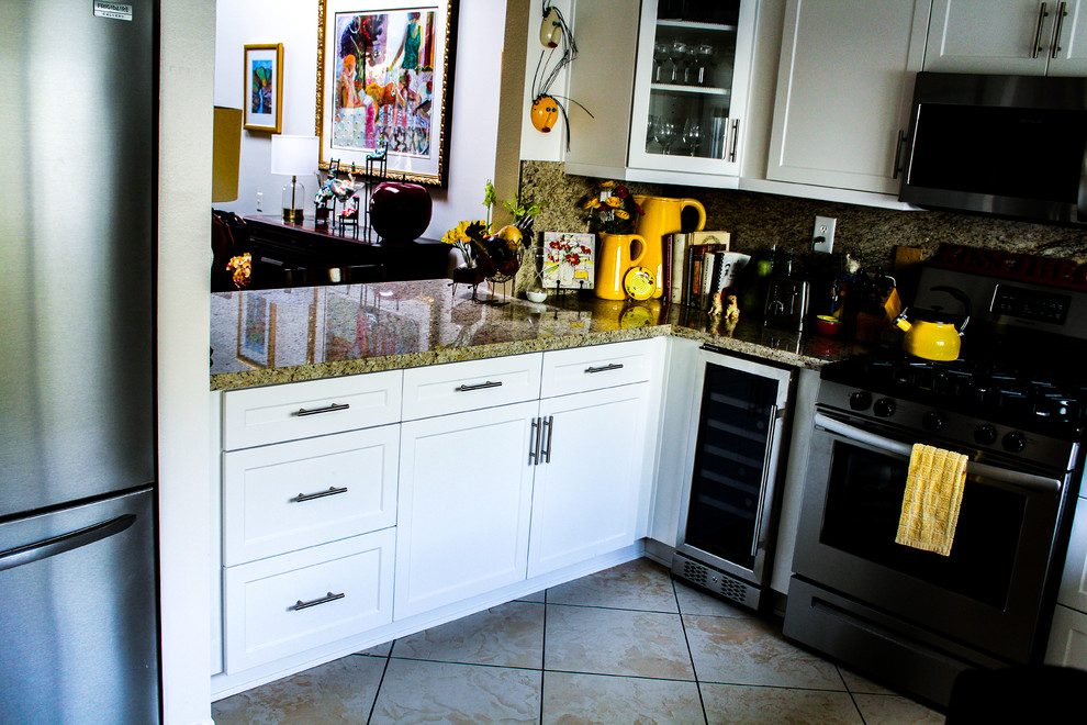 Example of a mid-sized transitional u-shaped porcelain tile and beige floor enclosed kitchen design with an undermount sink, shaker cabinets, white cabinets, granite countertops, brown backsplash, stone slab backsplash, stainless steel appliances, no island and brown countertops