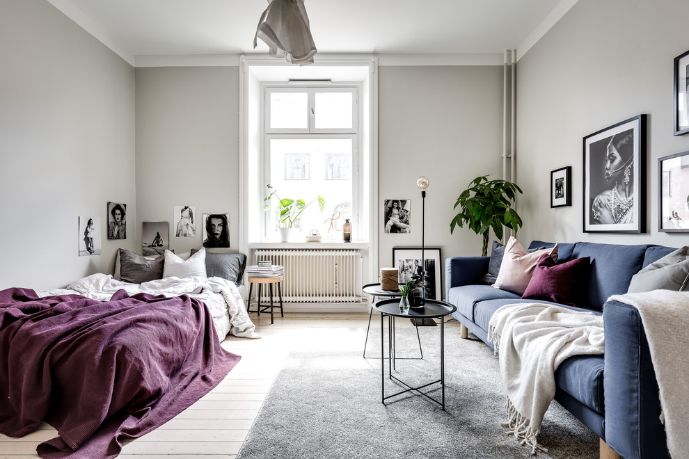 Photo of a mid-sized scandinavian living room in Stockholm with white walls, light hardwood floors and white floor.